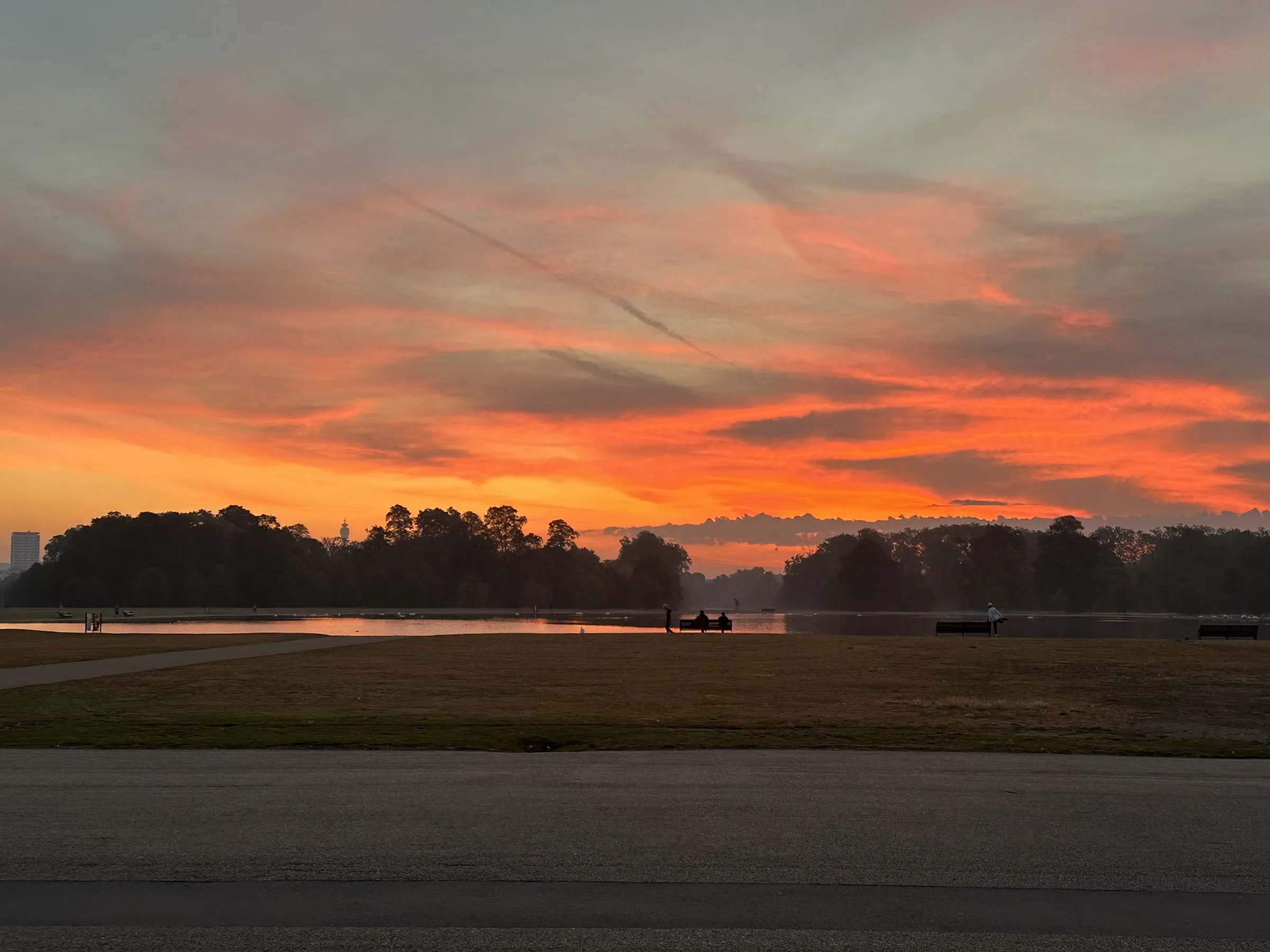A red and orange sky over a flat line of trees at sunrise