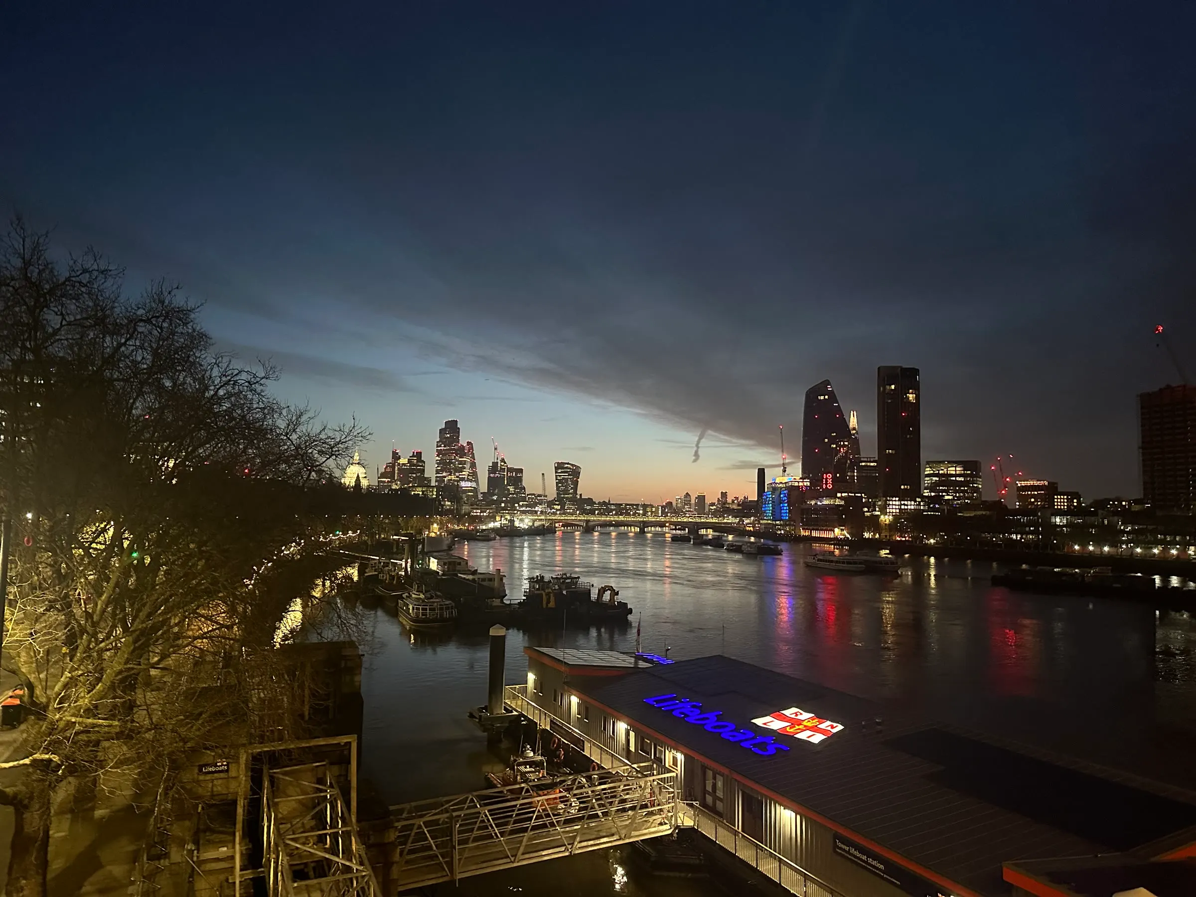 The Thames before dawn with the City of London illuminated beyond the river